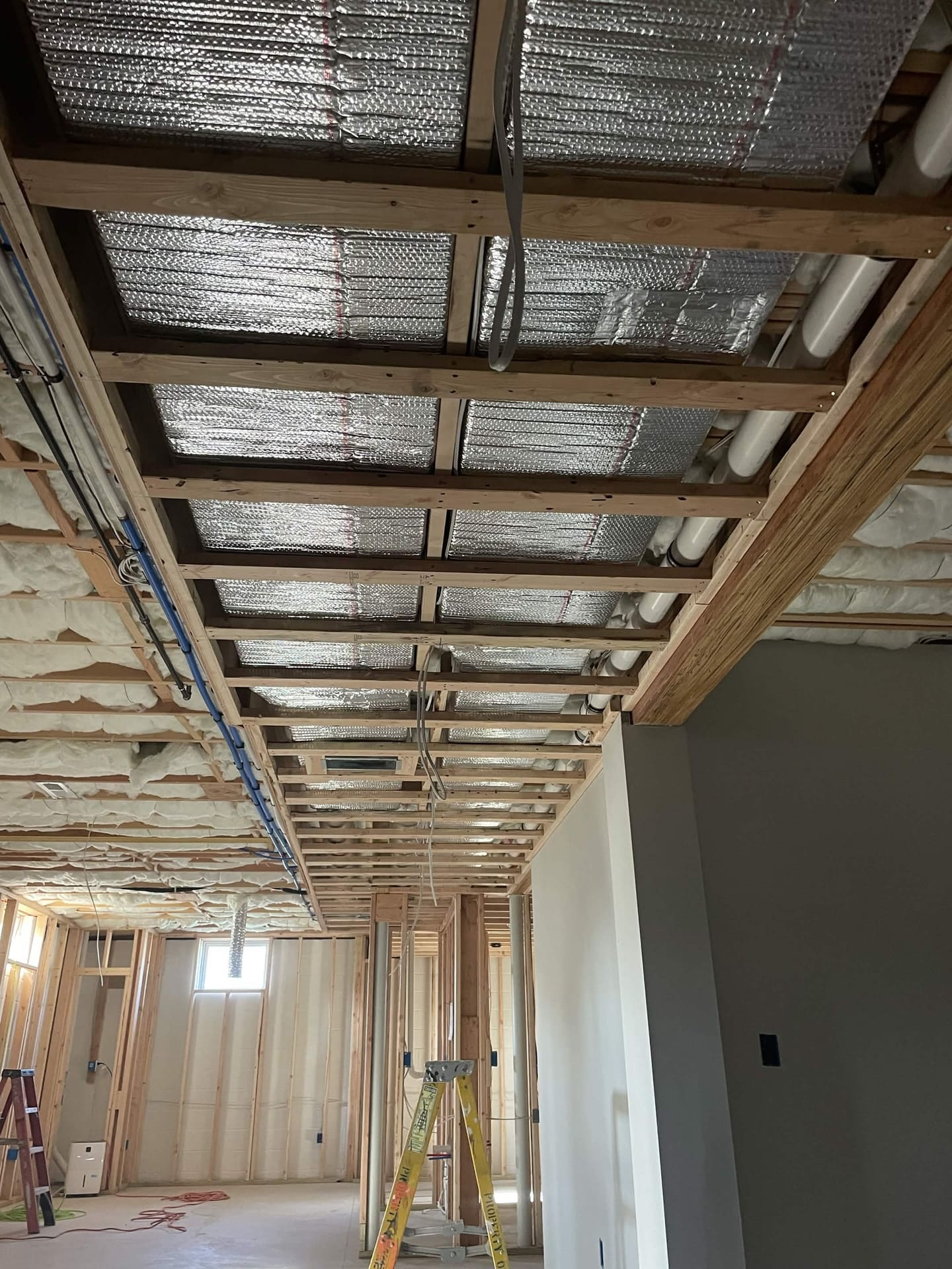 Basement ceiling rough-in with framing, insulation, and mechanical runs by Cursi Construction Inc.