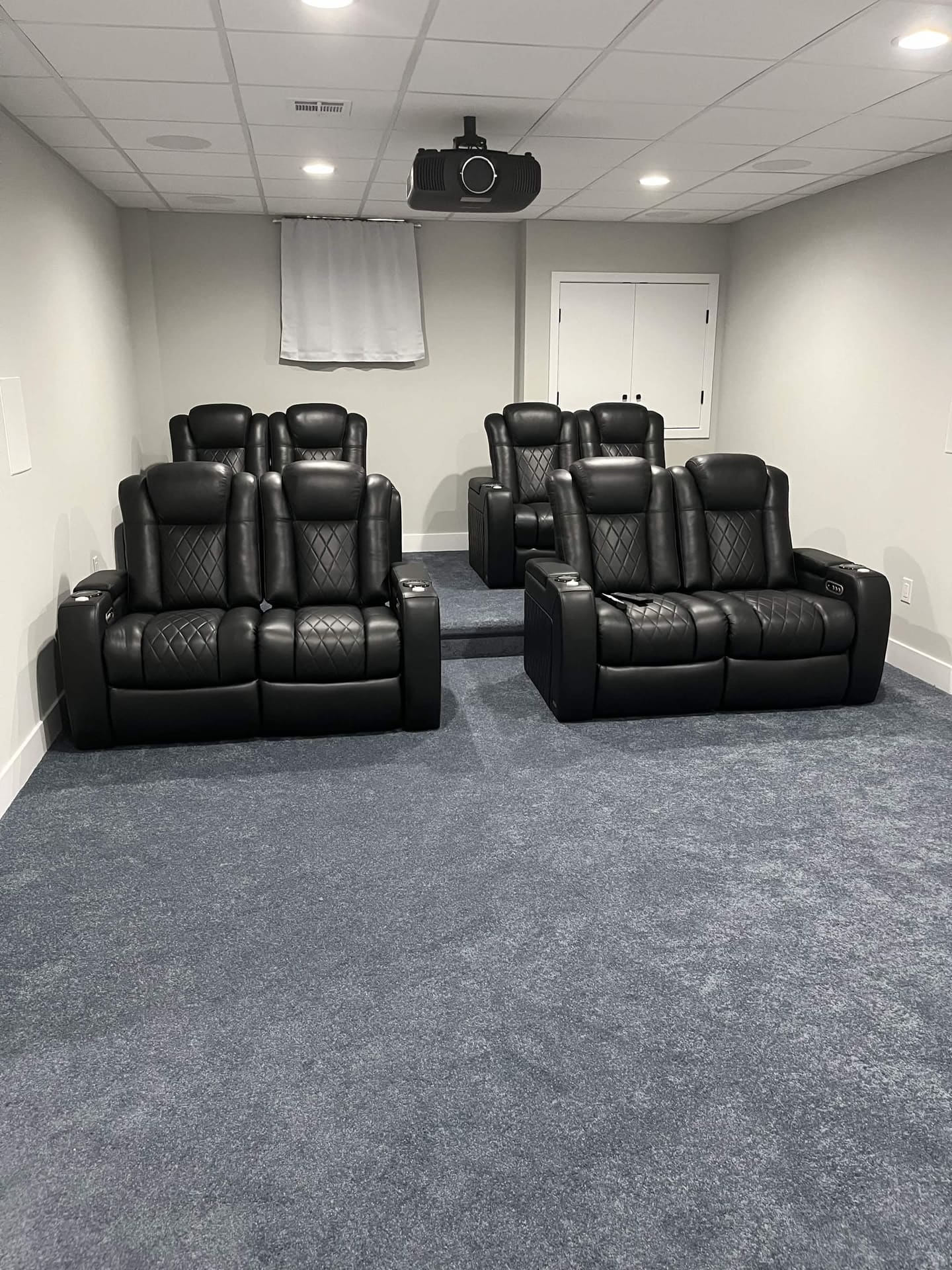 Finished basement home theater with tiered seating by Cursi Construction Inc.