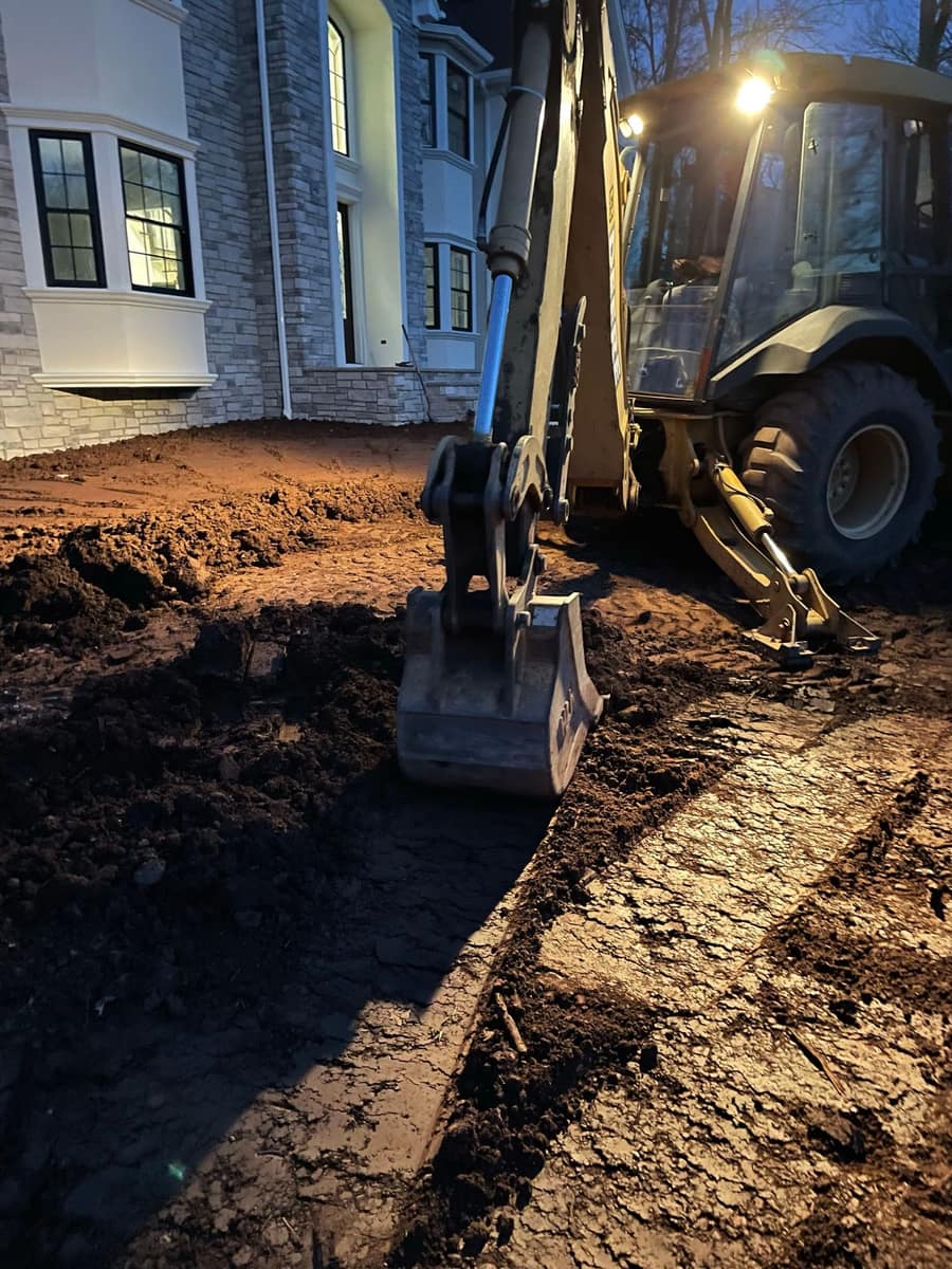 Foundation drainage trench and excavation work beside a new home by Cursi Construction Inc.