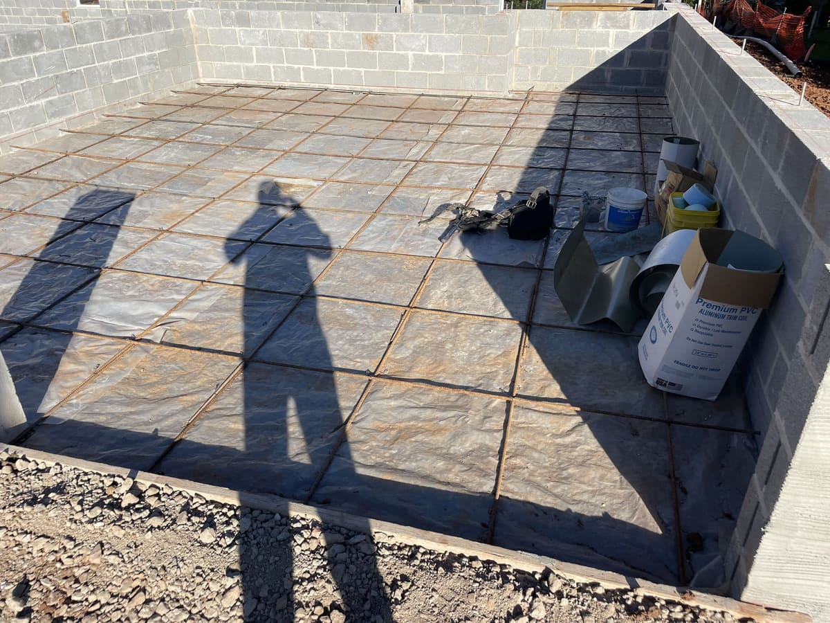 Masonry foundation and prepared base area with block wall and construction materials by Cursi Construction Inc.