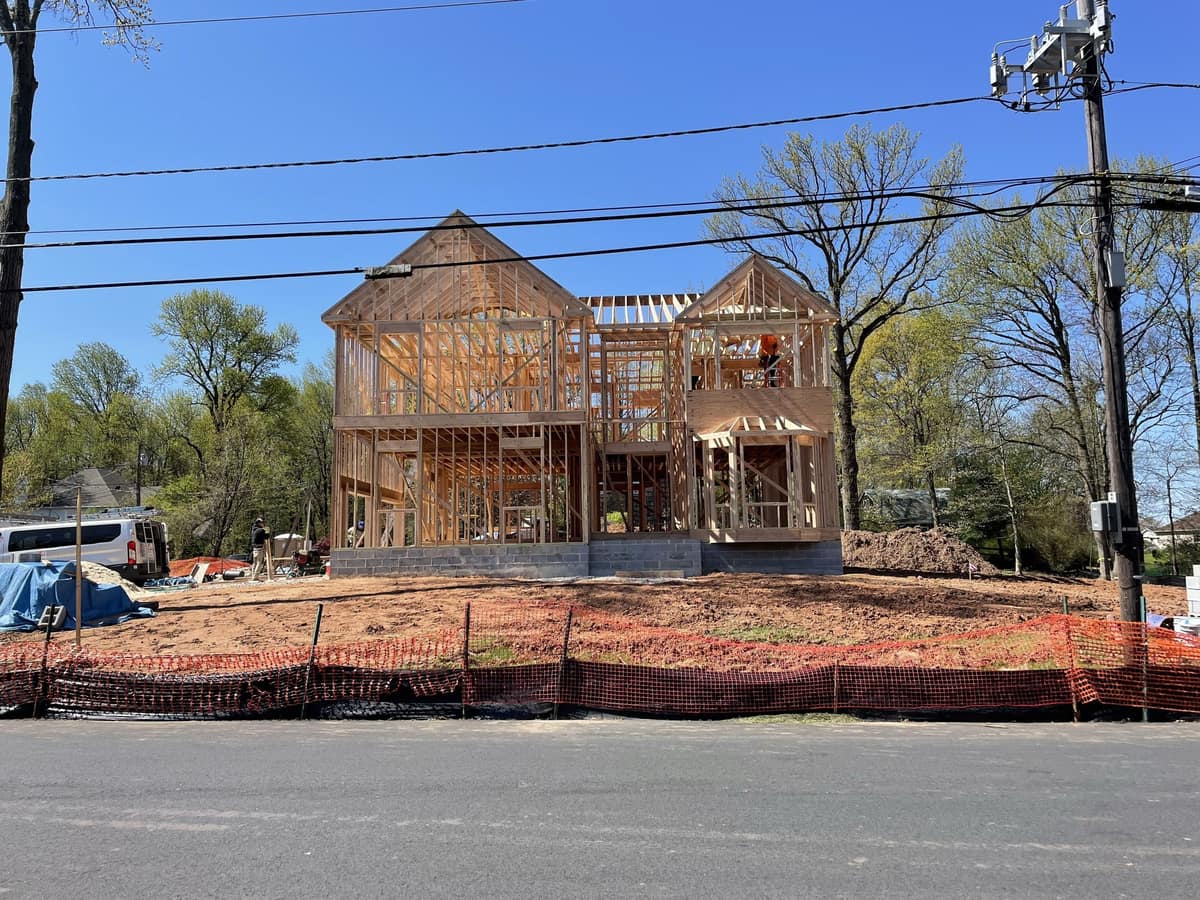New home framing in progress viewed from the street with wood framing and front porch structure, built by Cursi Construction Inc.
