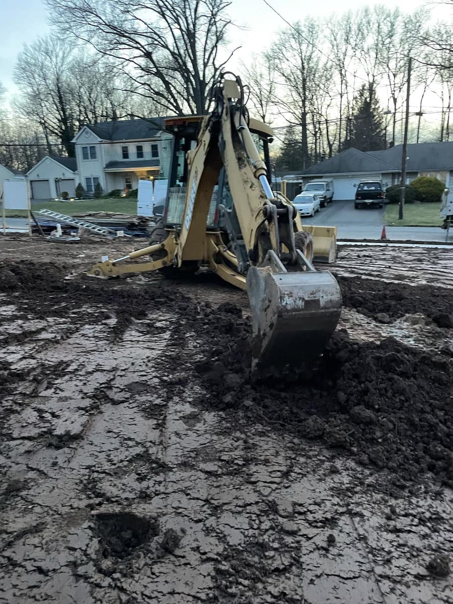 Excavation equipment preparing a residential construction site for Cursi Construction Inc.