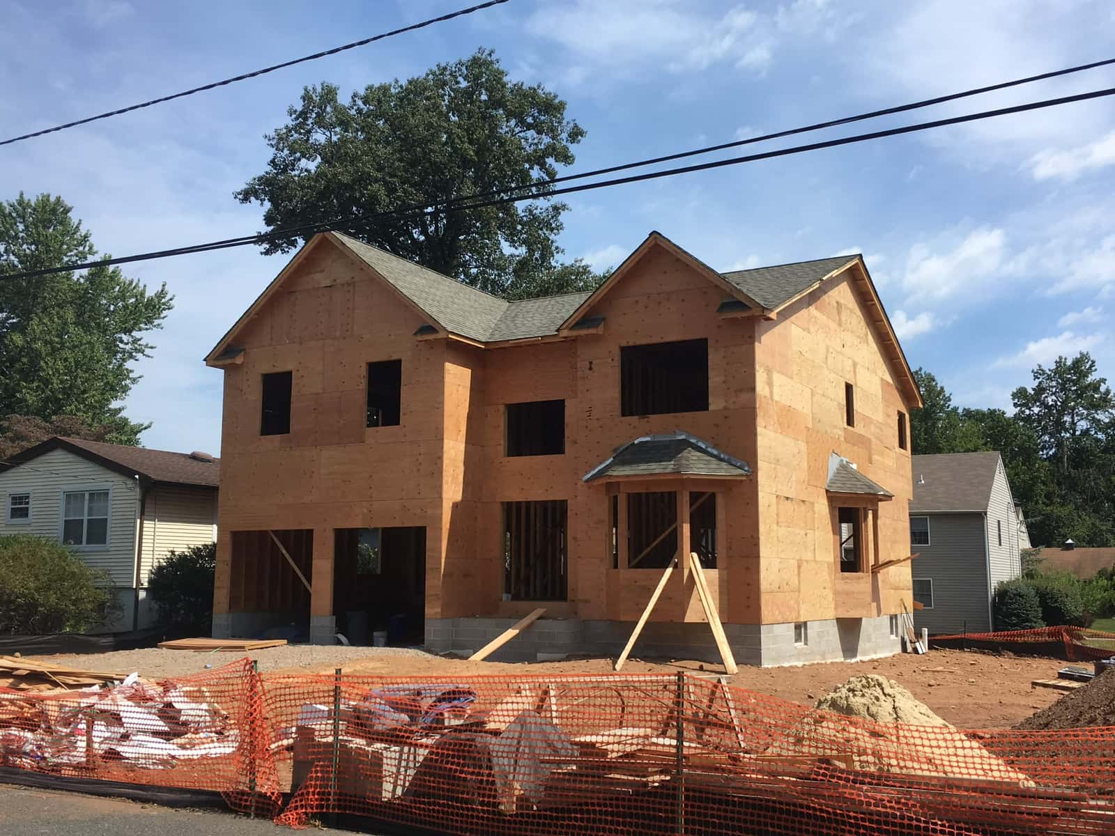 New home exterior sheathing and roof installation underway on a residential construction site, by Cursi Construction Inc.