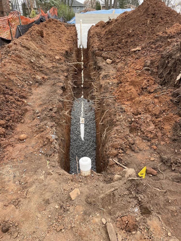 Underground plumbing rough-in trench for a residential construction project by Cursi Construction Inc.